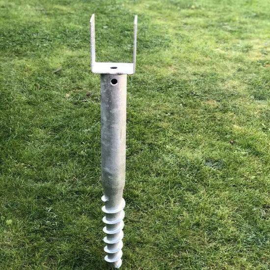 Galvanized ground anchor with U-shaped top for securing fences or structures in grassy areas