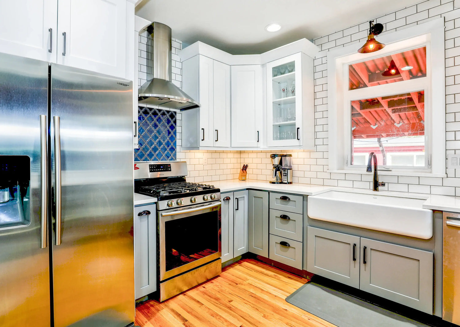 Modern kitchen with stainless steel appliances, white subway tile, and gray cabinets