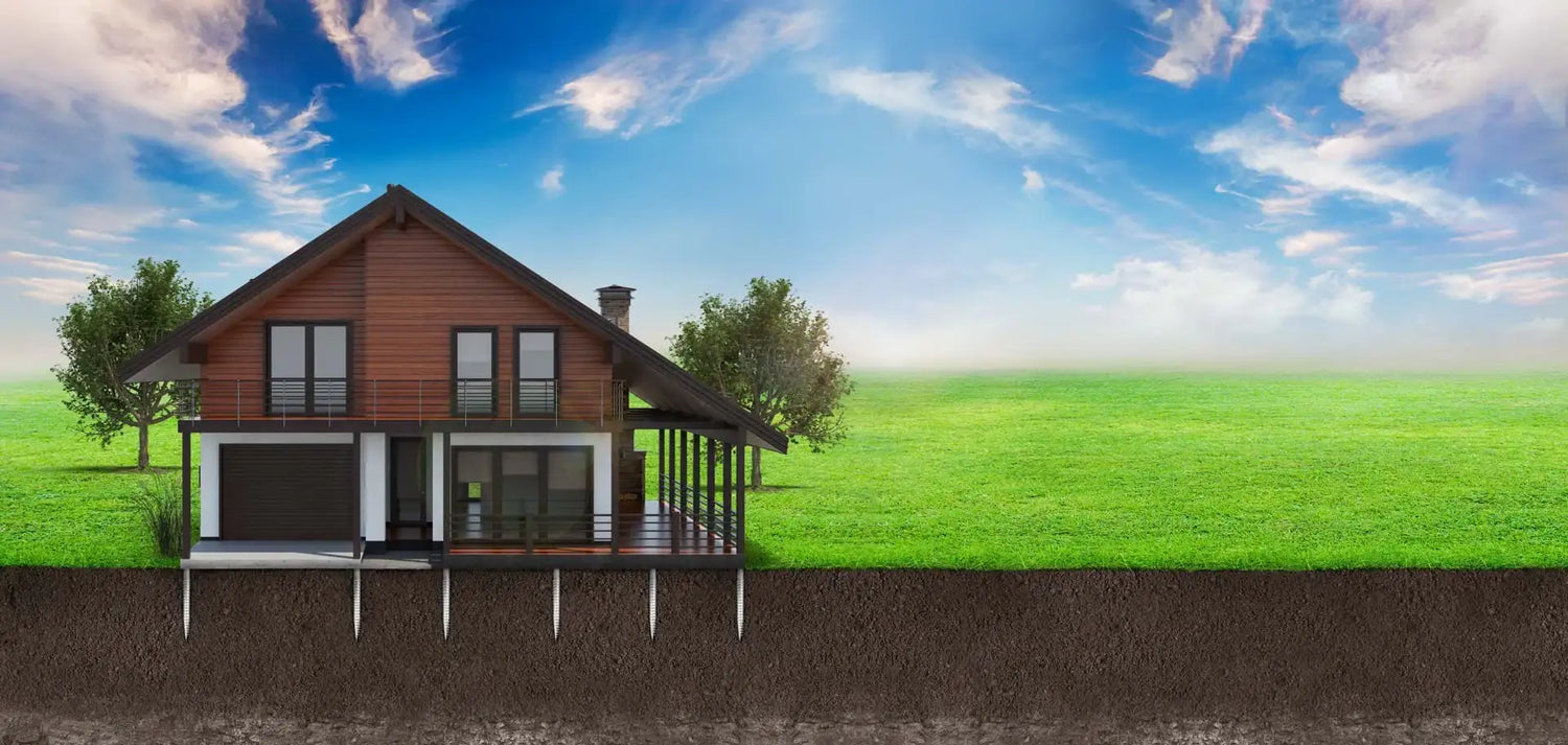 Modern house with visible foundation piles on green field under blue sky