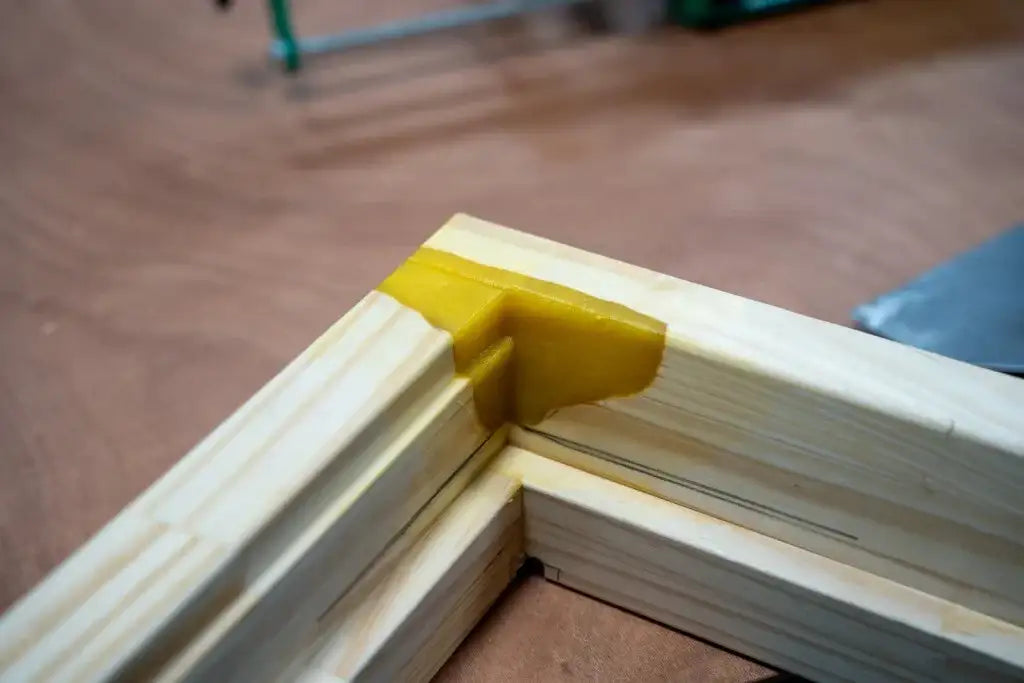 Wood frame corner with yellow adhesive, ideal for industrial assembly and manufacturing projects